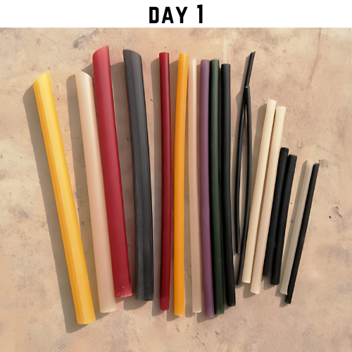 A colorful assortment of rice straws arranged on a surface, labeled 'DAY 1'. Straws in various colors such as yellow, red, black, purple, and beige are visible.